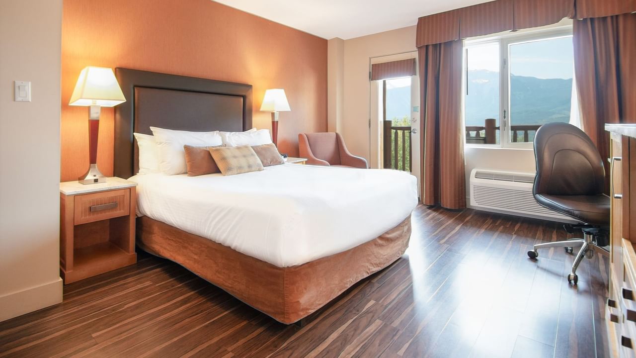 Hotel guestroom with queen bed and a balcony