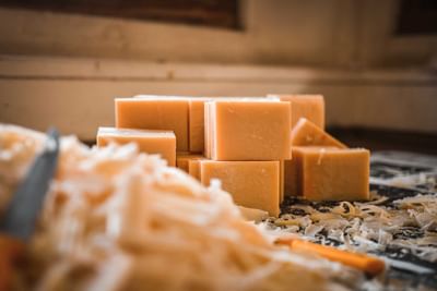 Neatly arranged, light orange soap bars sit on a wooden table covered with shavings at The Dwarika’s Hotels and Resorts