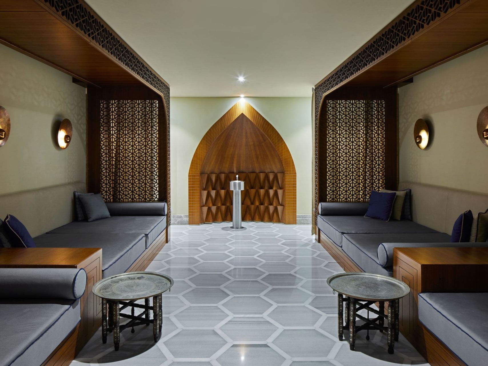 Eleganter Raum mit Couches, runden Tischen, Wandpaneelen und Wandlampen – Titanic Chaussee Berlin.