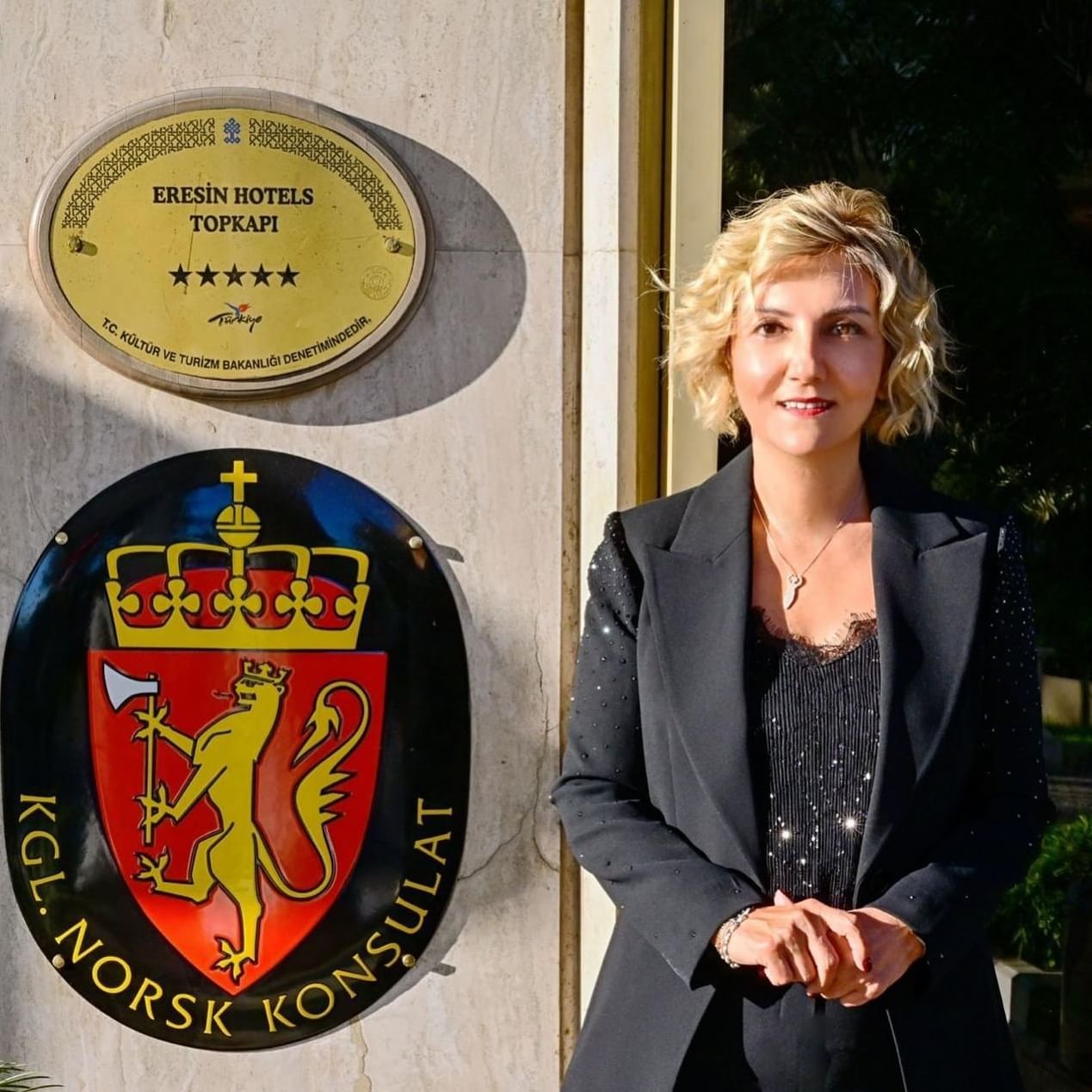 Eine Frau steht vor einer Wand mit Schildern
