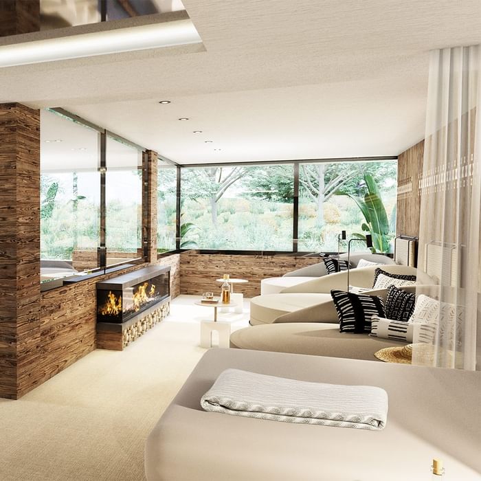 Modern lounge with large windows, wood paneling, fireplace, and furniture with black and white patterned cushions.