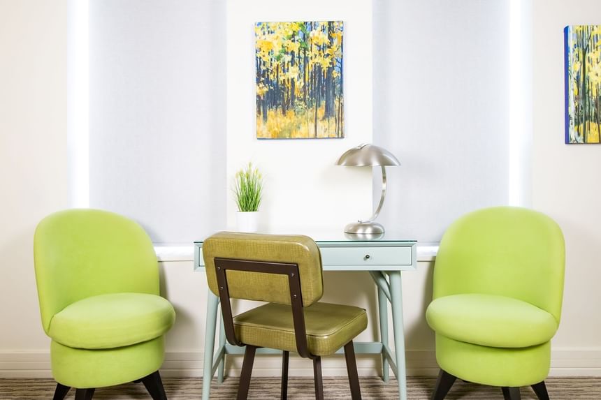 Two green chairs & work desk with lamp in Queen Premiere Sunset at Retro Suites Hotel
