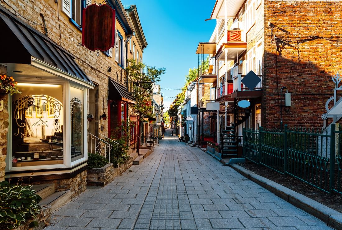 Rue pavée avec boutiques et bâtiments en brique à Warwick Le Crystal Montreal