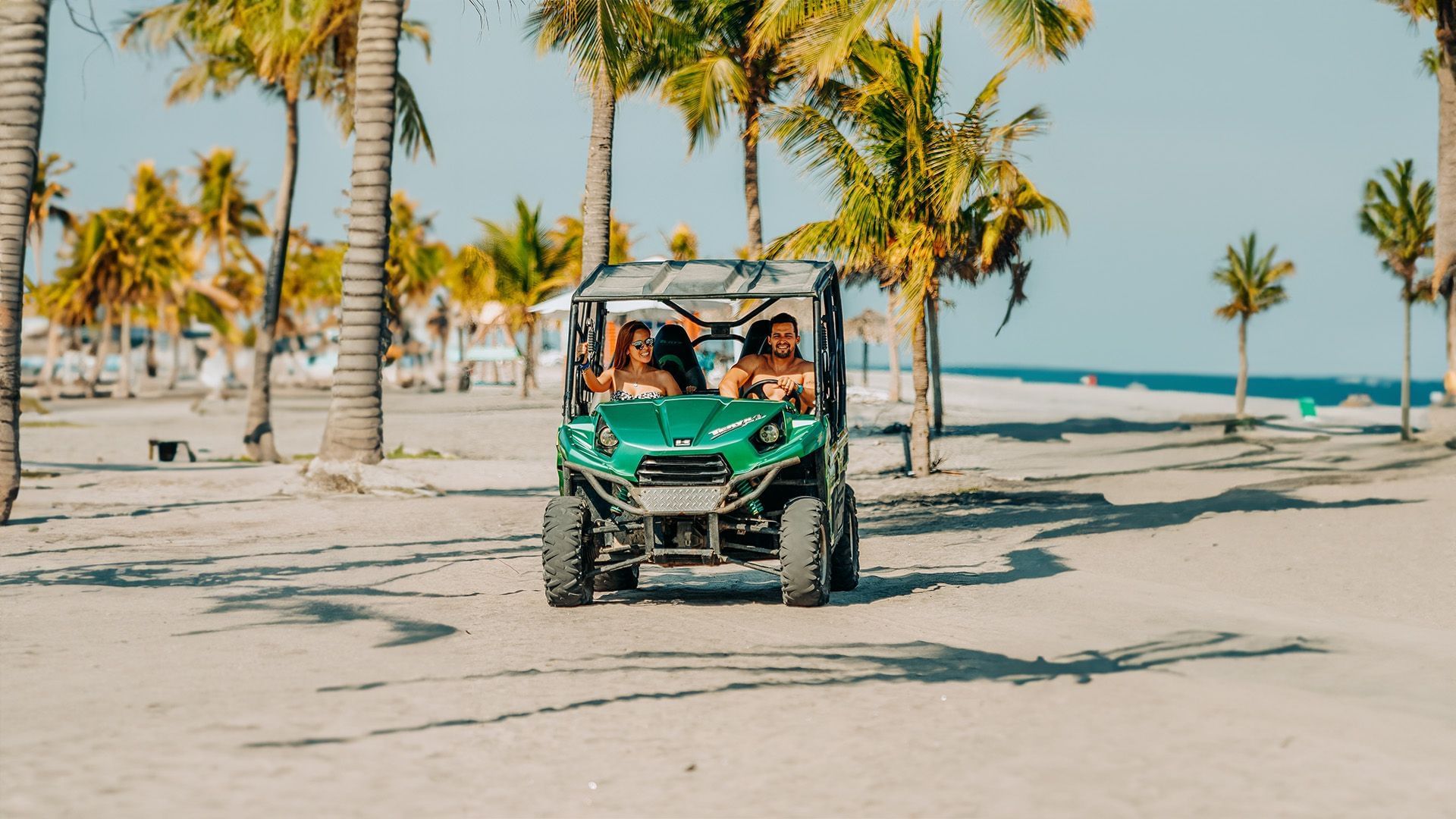 Couple riding ATV on sandy beach at Playa Blanca Beach Resort