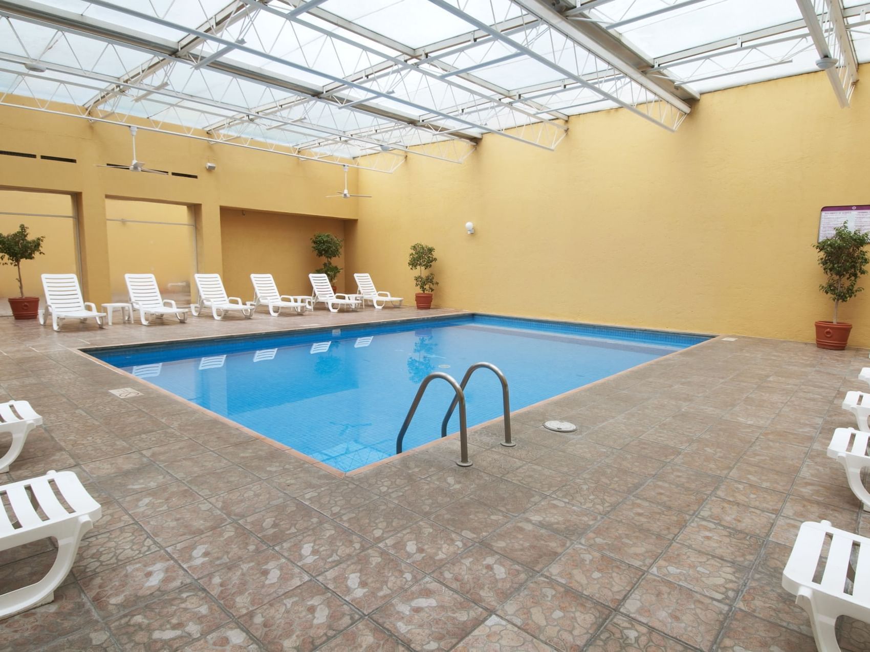 Indoor swimming pool area with sunbeds at Fiesta Inn