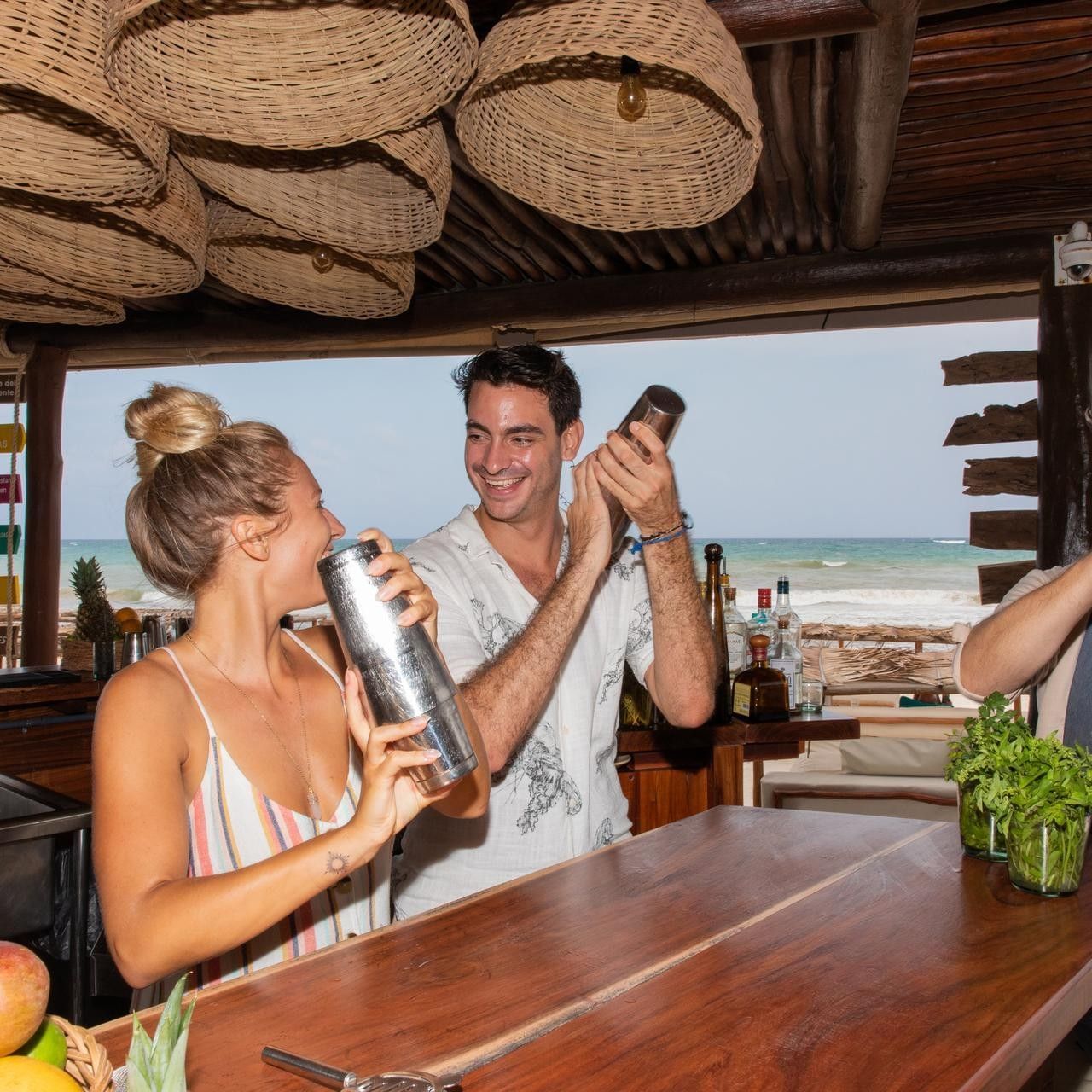 Guests participating in a fun cocktail-making class behind the wooden bar at La Zebra Hotel