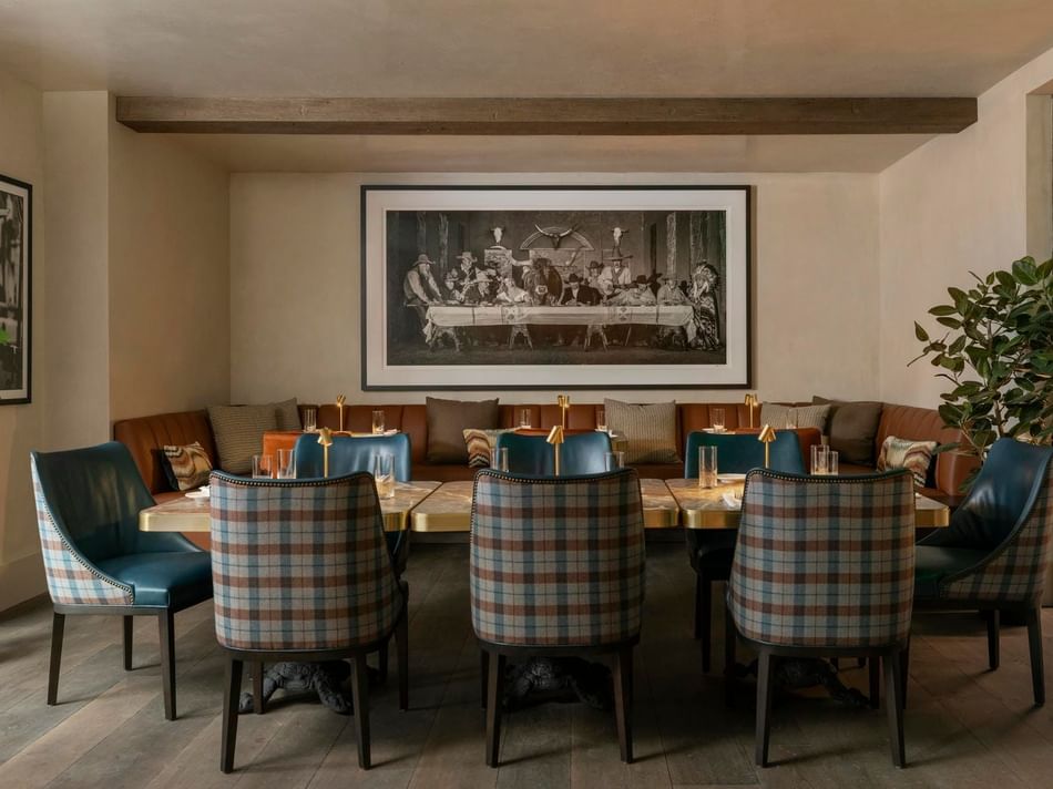 Stylish Remi interior at Granduca Houston with a dining table, plush seating, and large vintage artwork