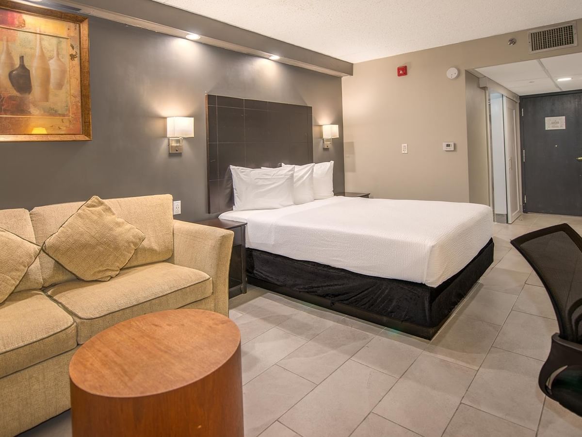 Accessible room with a bed, couch, chair, and table.