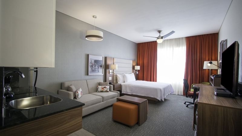 Bed and a Couch in Suite Queen room at Fiesta Inn Suites Aeropuerto del Bajío Silao