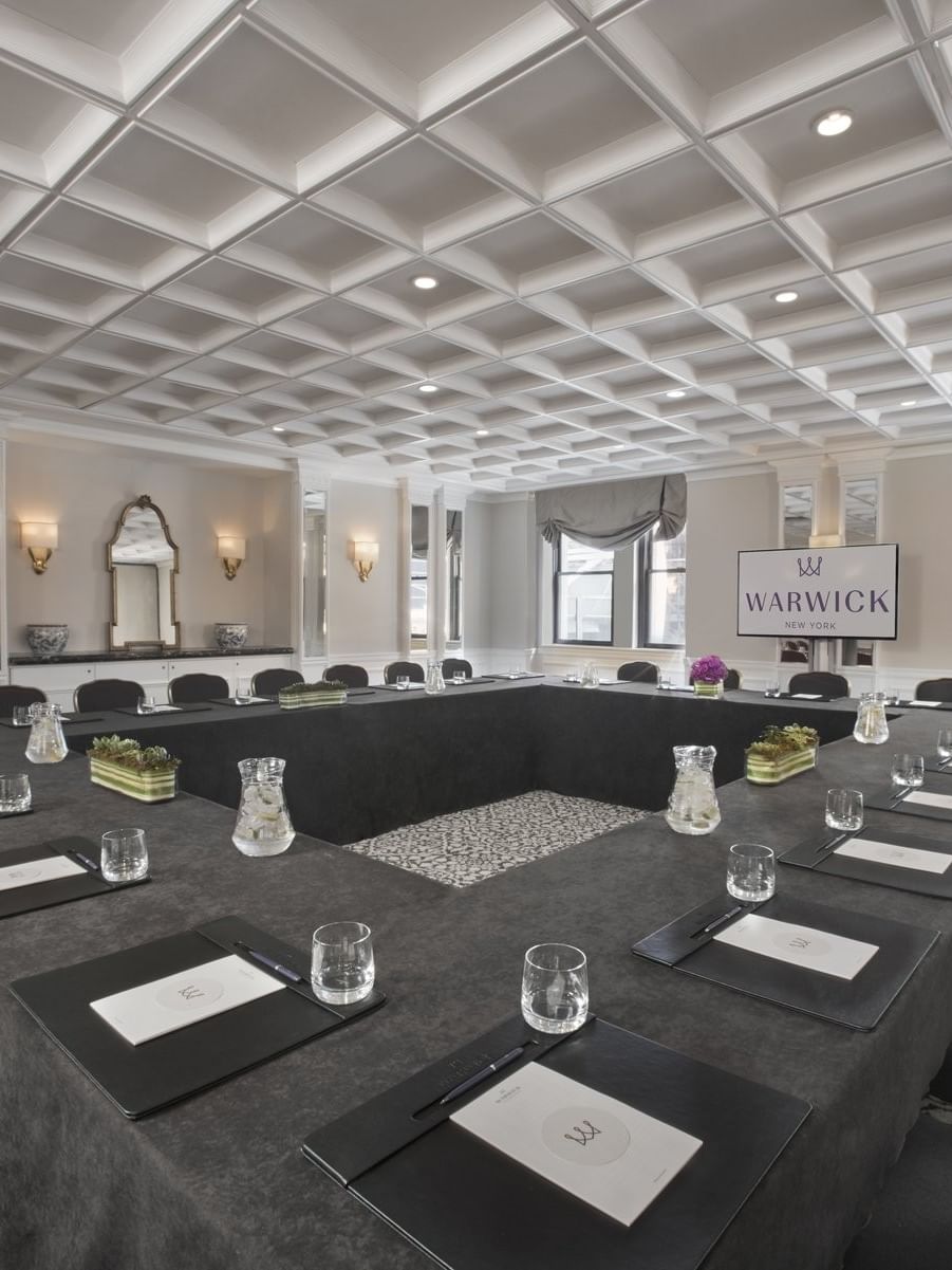 Boardroom table set-up facing TV near window in Oxford meeting room at Warwick New York