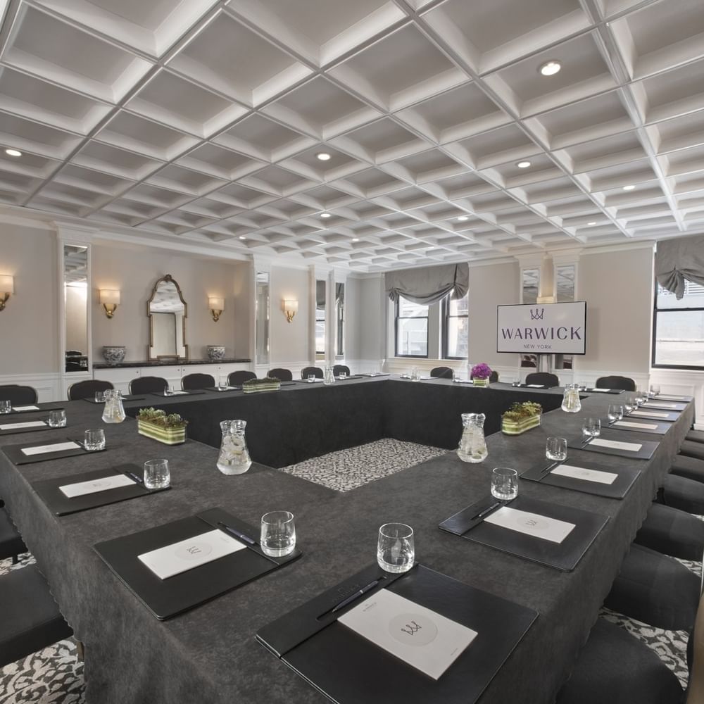 Boardroom table set-up facing TV near window in Oxford meeting room at Warwick New York