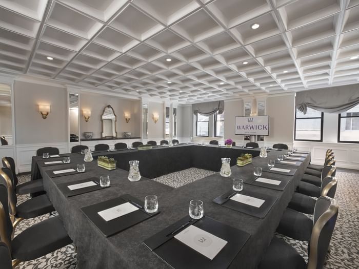 Boardroom table set-up facing TV near window in Oxford meeting room at Warwick New York