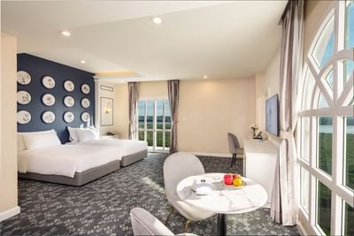 Fruits on a table by the comfy bed in Deluxe Balcony River View at Eastin Vientiane Laos