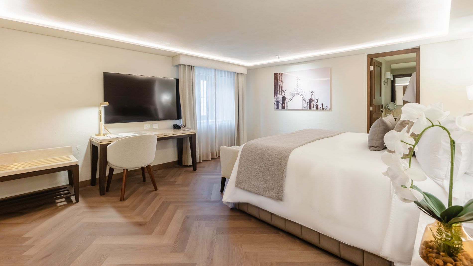King Deluxe with a cozy king bed, a work desk, and stylish herringbone wood floors at Quinta Real Puebla
