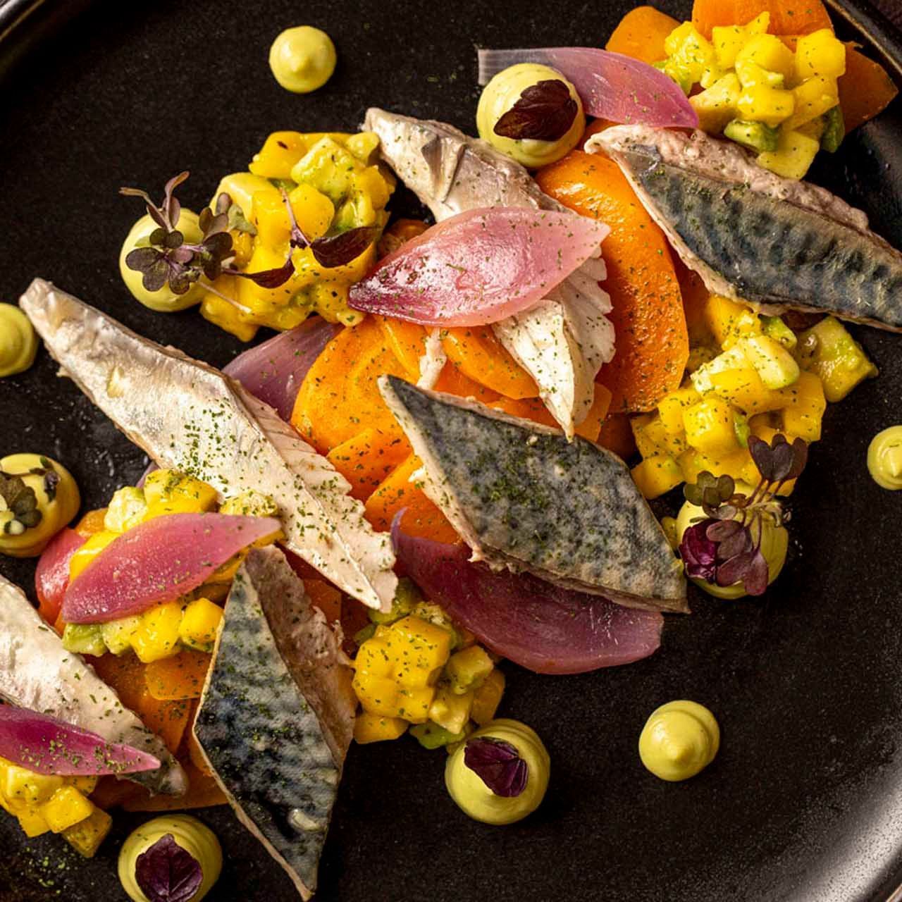 A plate of Mediterranean cuisine featuring fish, vegetables & olives in EMME Restaurant at Margutta 19