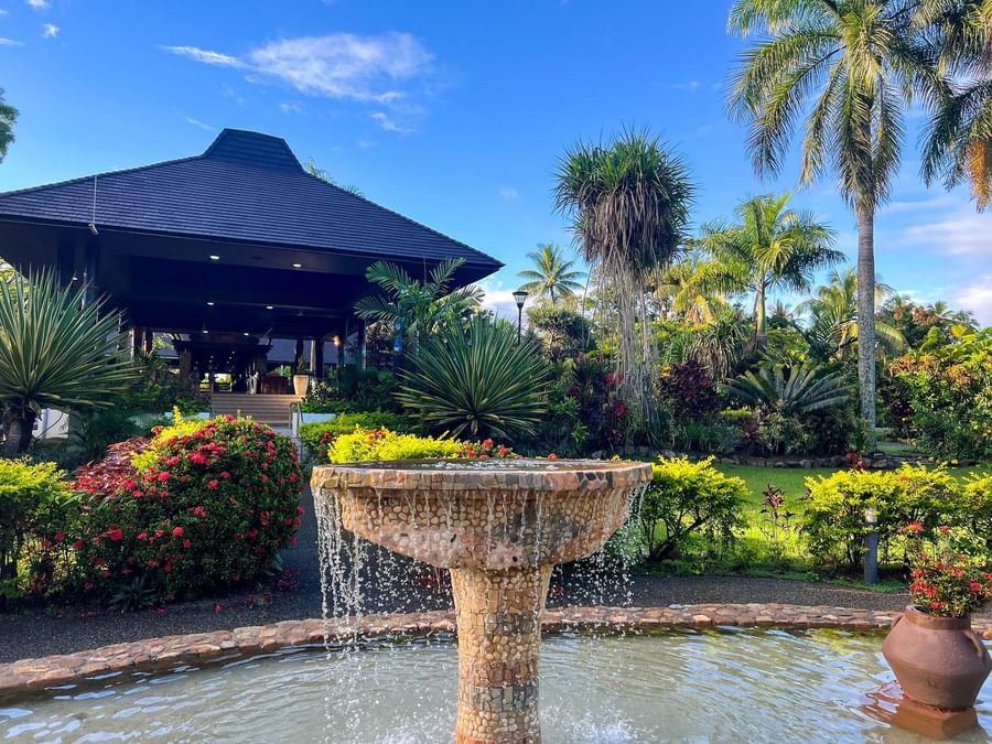 Stone fountain with water flowing surrounded by lush tropical greenery at The Naviti Resort Fiji.