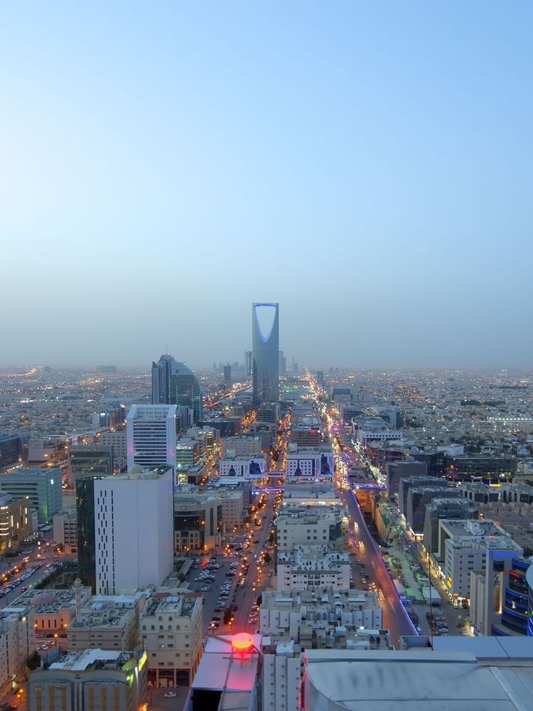 Vast city skyline with tall skyscrapers by a main road, under a hazy sky in Riyadh near Warwick Hotels & Resort