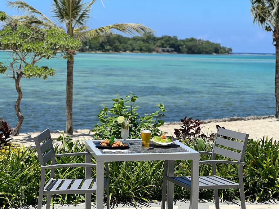 Outdoor table with food and drinks by the beach at Warwick Le Lagon - Vanuatu.