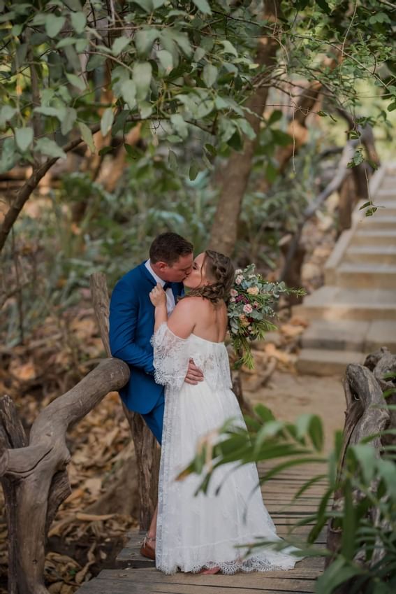 A wedded couple kissing each other at Cala Luna Boutique Hotel