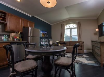 A modern suite with a dining area, kitchen, and living room at The Stanley Hotel, with a large window and a view