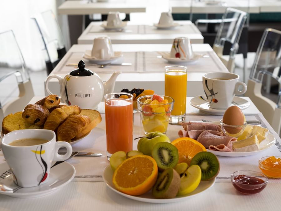 Breakfast table with fruits, juice at Hotel Novella Premium
