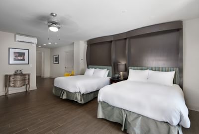 King Bed Partial View Connector at The White House Hotel, with two queen beds, dark headboards, wood floor, and ceiling fan