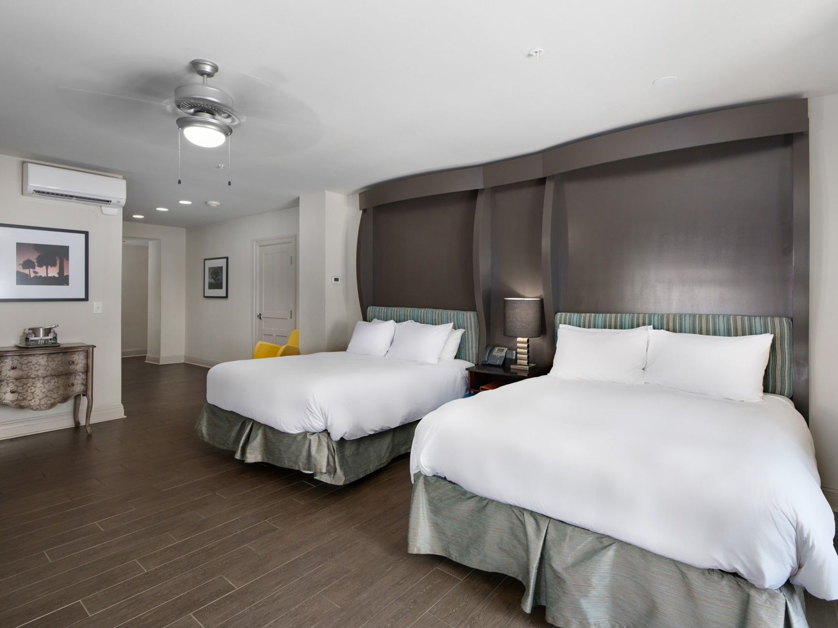 King Bed Partial View Connector at The White House Hotel, with two queen beds, dark headboards, wood floor, and ceiling fan