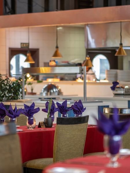 Red-clothed dining tables featuring vibrant purple napkins in KanaVata Restaurant at TokaToka Resort Nadi Fiji