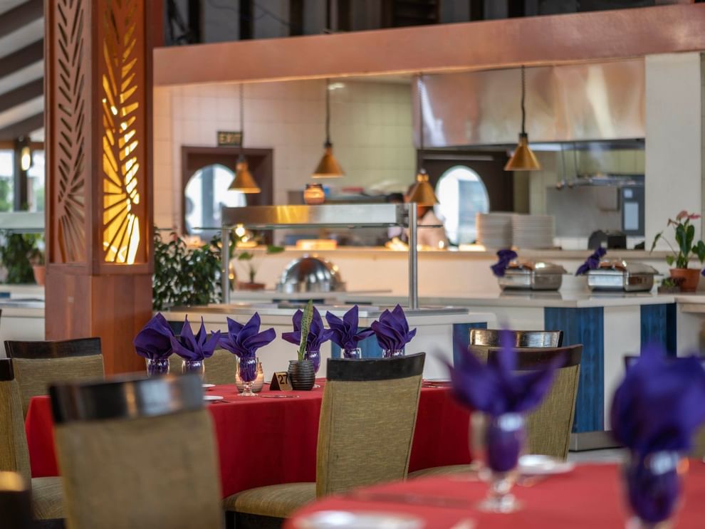 Red-clothed dining tables featuring vibrant purple napkins in KanaVata Restaurant at TokaToka Resort Nadi Fiji