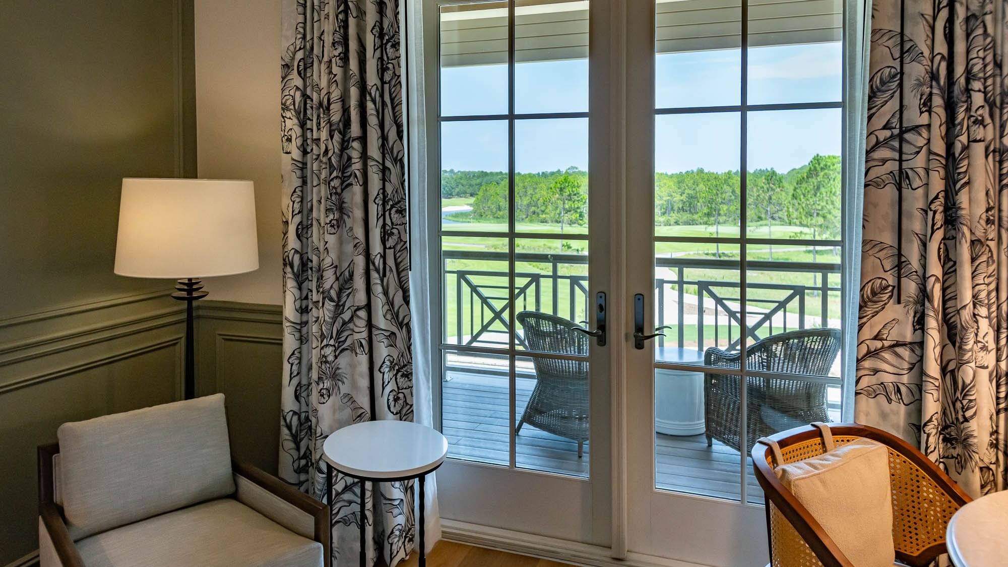 Cozy seating area with balcony overlooking lush greenery at Camp Creek Inn in Inlet Beach
