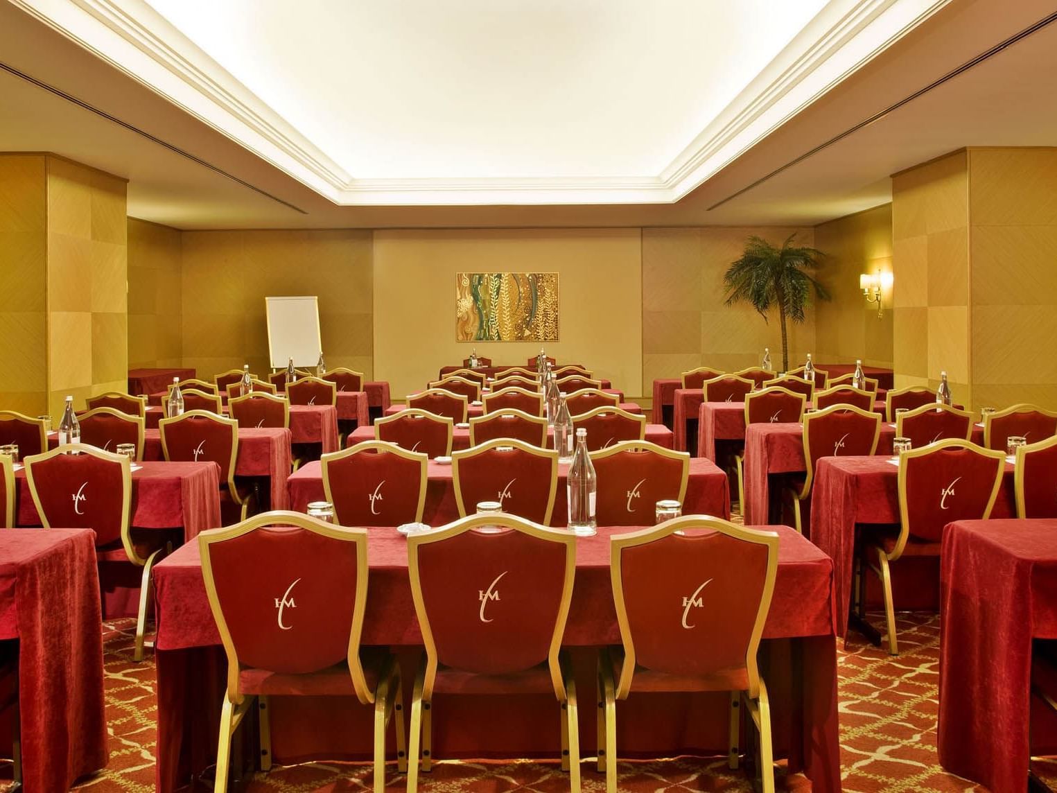 Room with red chairs and tables in row at Hotel Cascais Miragem