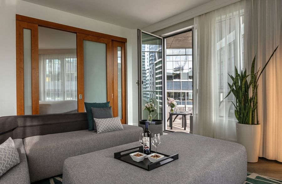 Warwick Premier Suite with a living area with a sofa by a glass door open to the balcony at Warwick Le Crystal Montreal