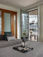 Warwick Premier Suite with a living area with a sofa by a glass door open to the balcony at Warwick Le Crystal Montreal