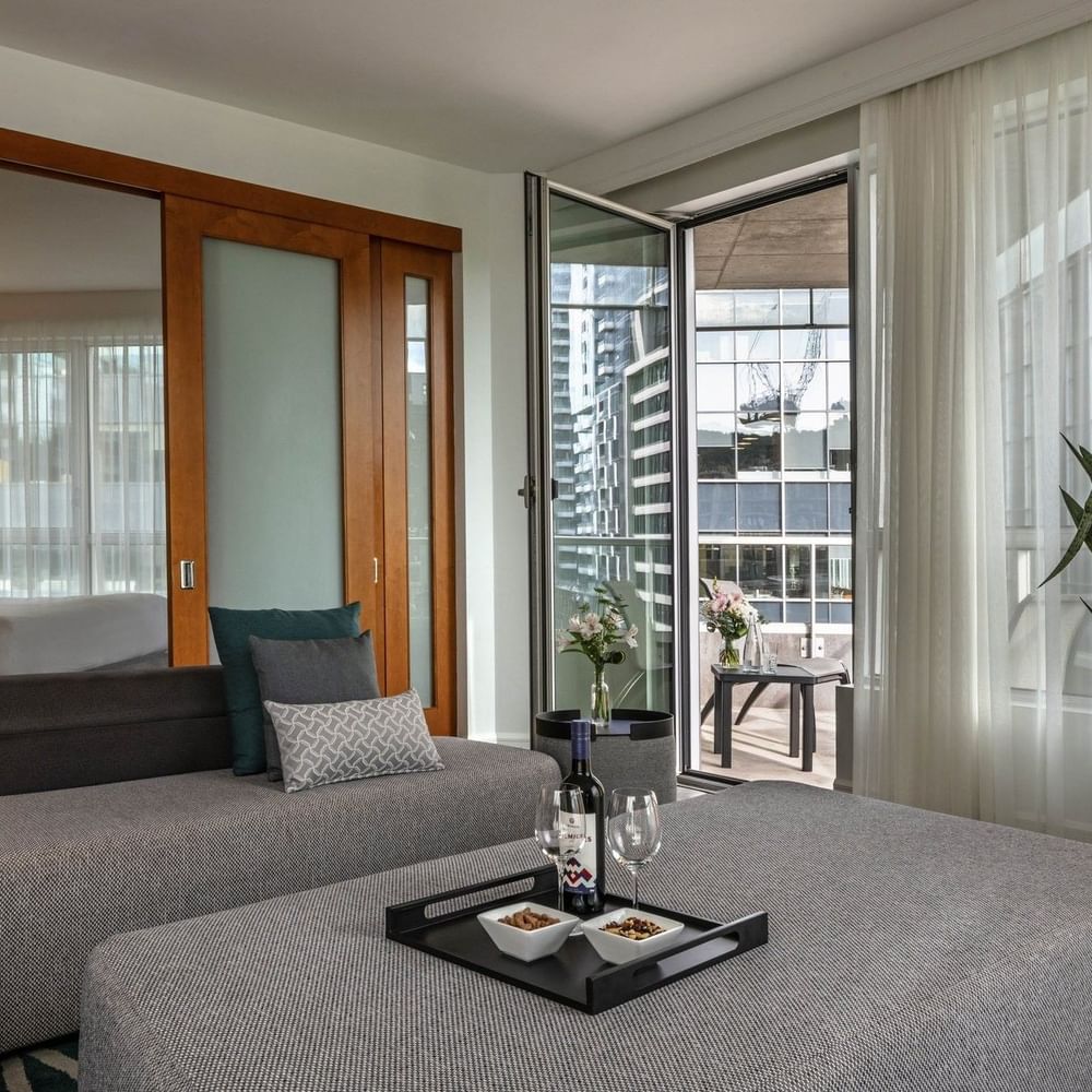 Warwick Premier Suite with a living area with a sofa by a glass door open to the balcony at Warwick Le Crystal Montreal