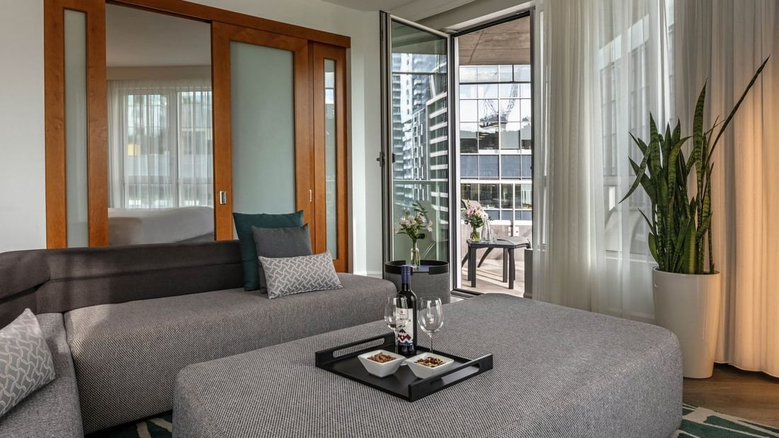 Warwick Premier Suite with a living area with a sofa by a glass door open to the balcony at Warwick Le Crystal Montreal