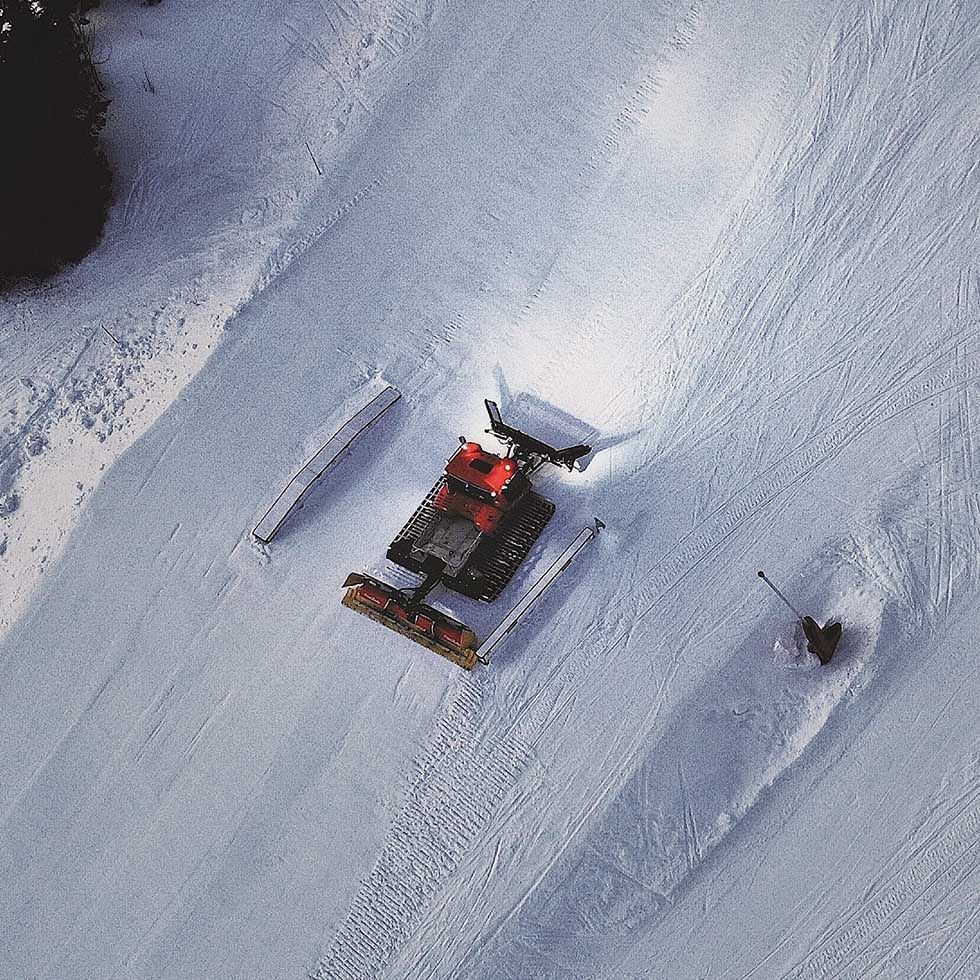 Aerial view of a snow groomer near Falkensteiner Hotels