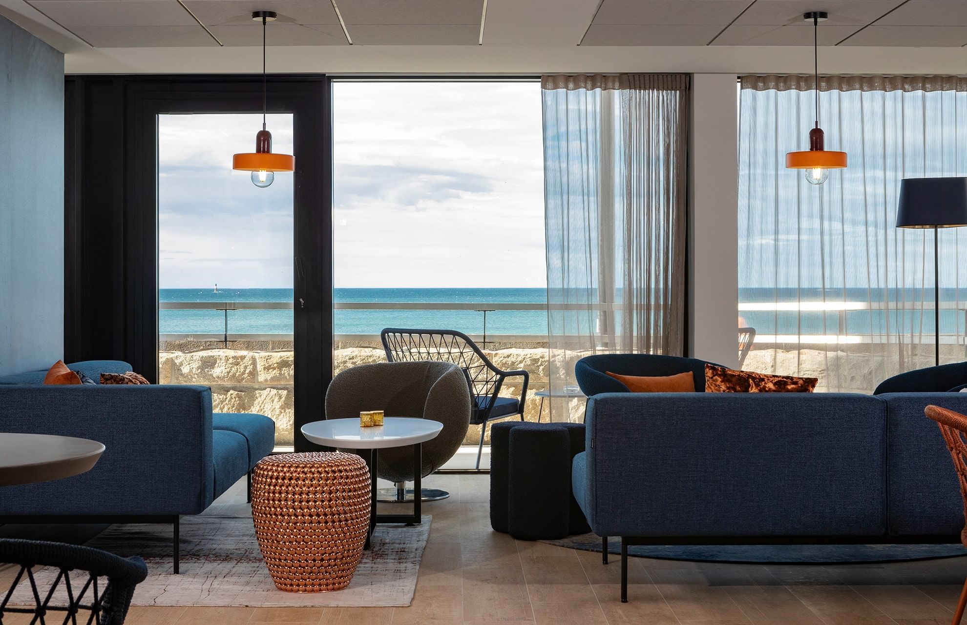 Coin salon avec canapé et table basse avec vue sur la mer à l'Oceania Saint-Malo