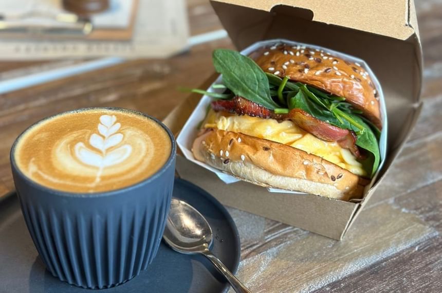 Close-up of a burger & latte served at Brady Hotels Central Melbourne