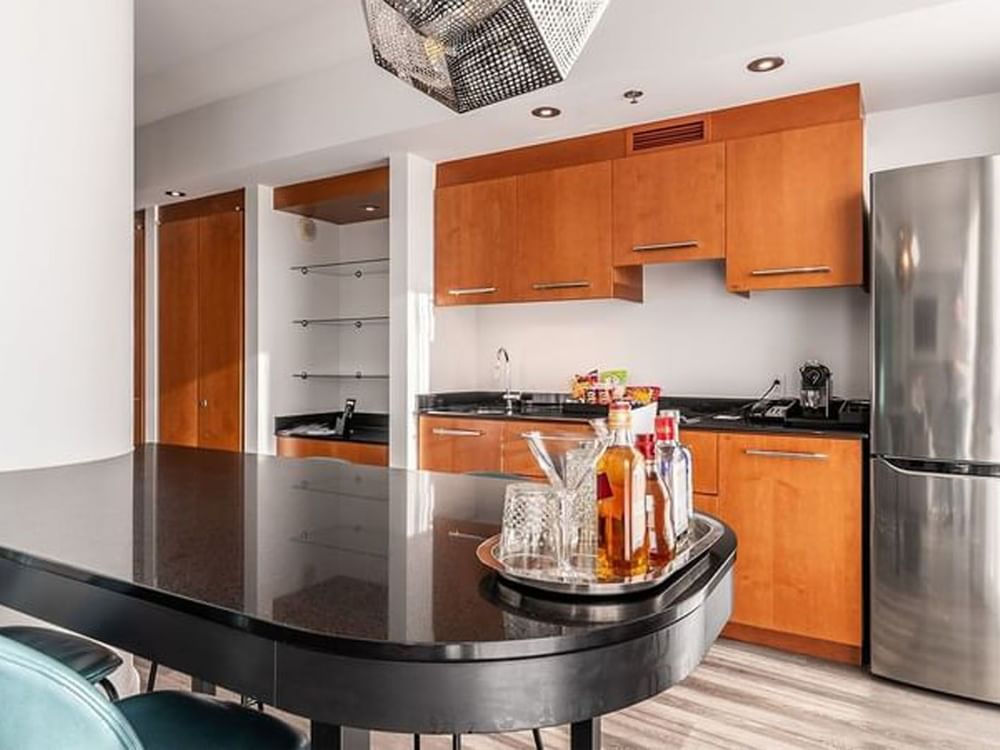 Kitchenette with cabinets and dining table in Penthouse Crescent at Warwick Le Crystal Montreal