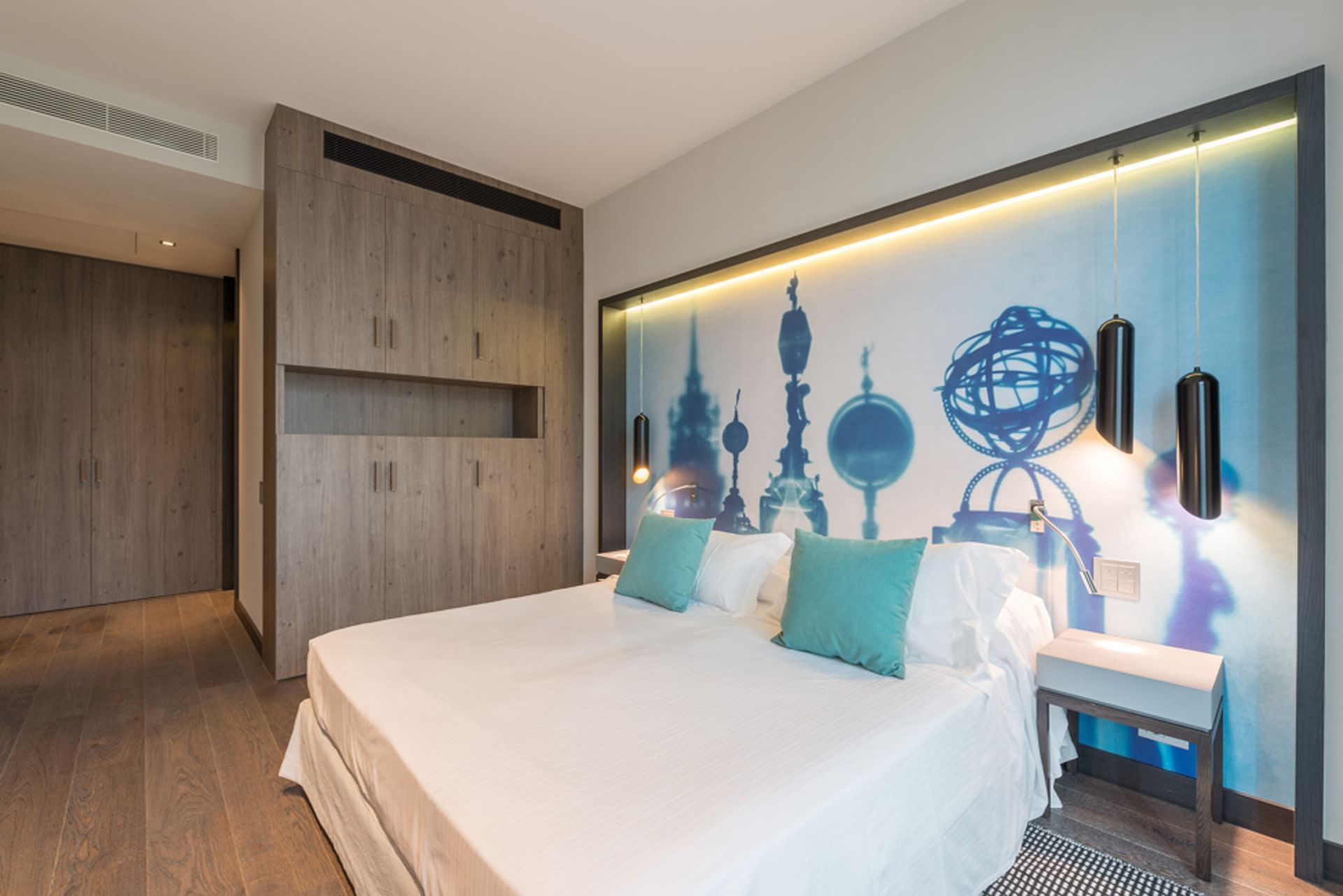 Suite elegante camera con letto matrimoniale, cuscini azzurri, e murale artistico su DUPARC Contemporary Suites