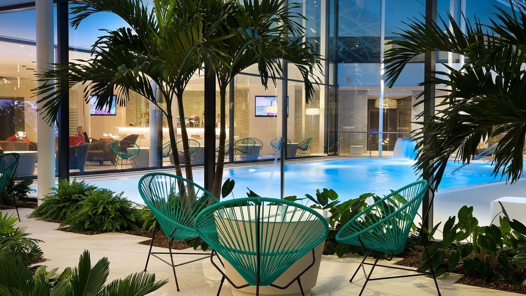 Piscine extérieure avec palmiers à Oceania Paris Roissy CDG