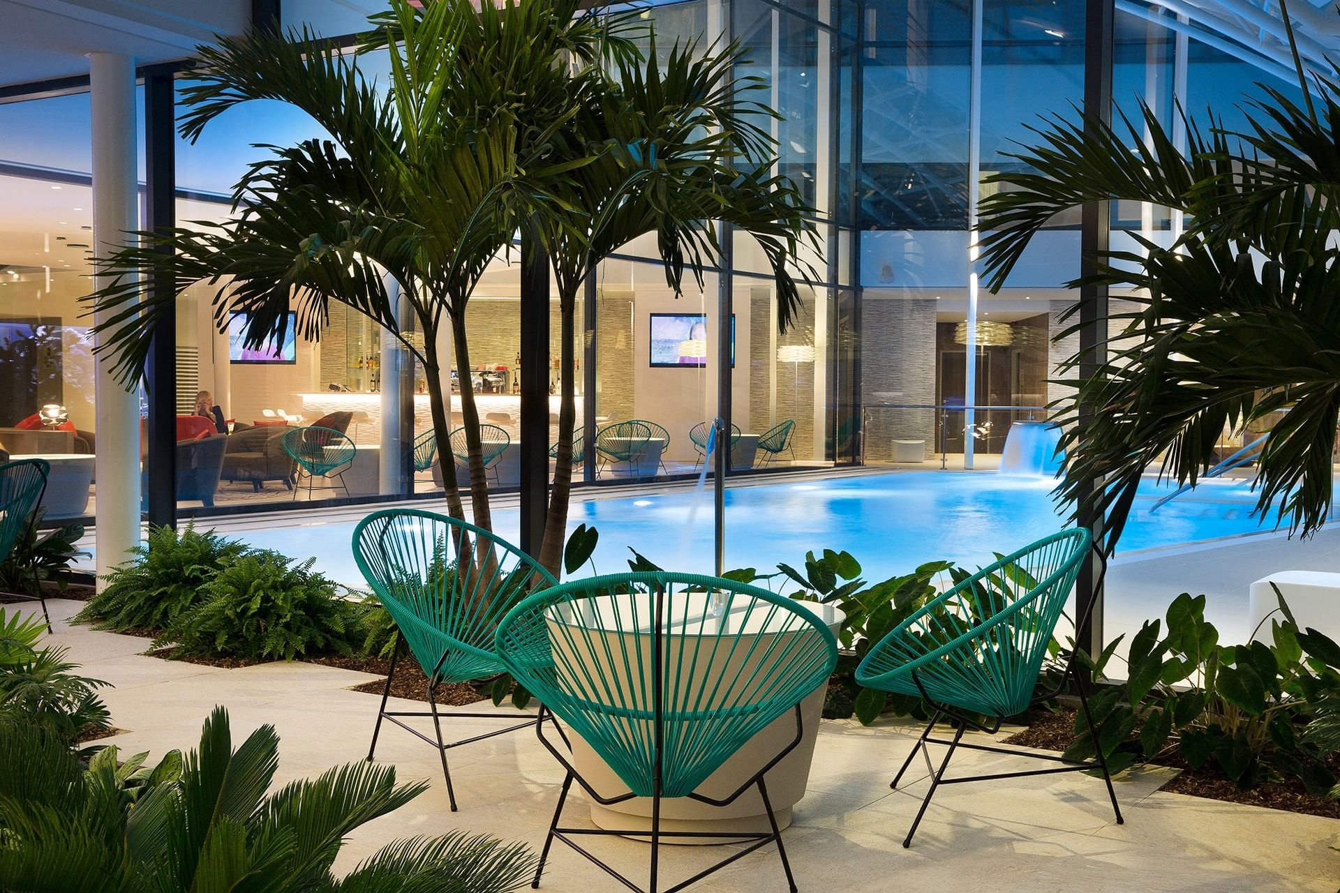 Espace piscine avec arbres et chaises à l'Oceania Paris Roissy CDG