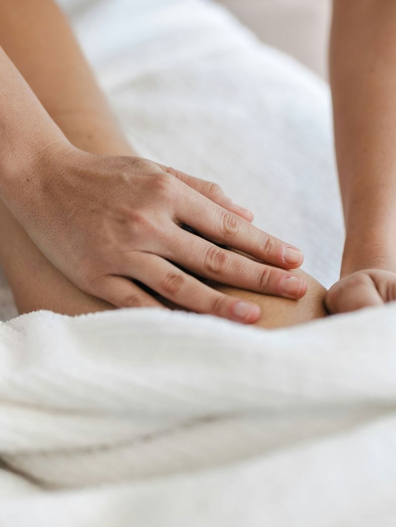 Elysium Manly hot stone therapy with a smooth basalt stone held in a therapist\’s palm, an apartment hotel in Manly