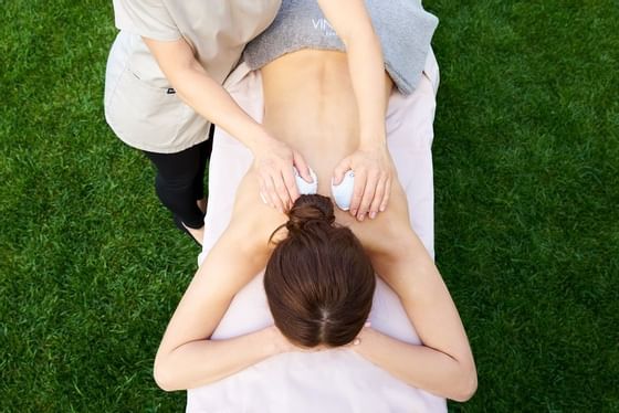 A lady receiving a body massage outside at Schloss Pichlarn