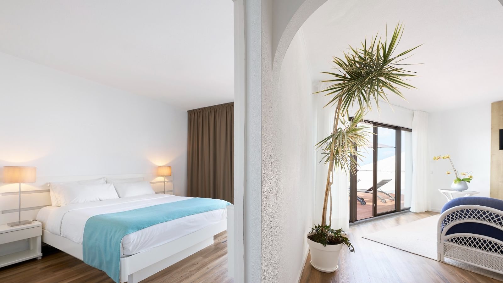 Bright suite with a bedroom area and a separate sitting area at Bensaude Hotels