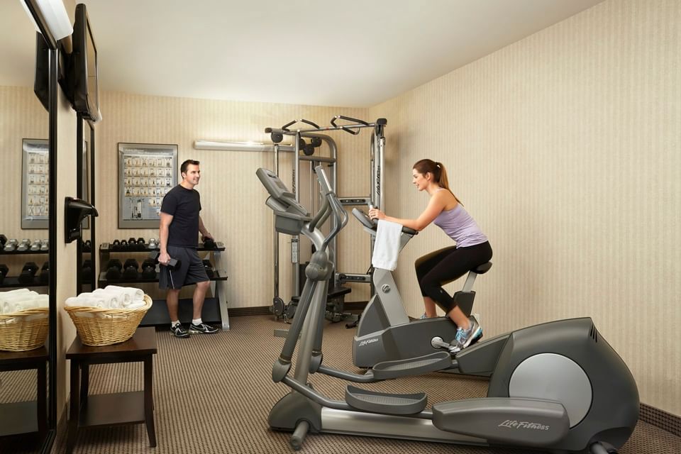 A couple working out with fitness room equipment at Acclaim Hotel Calgary