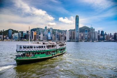 A ferry boat glides through the water near Park Hotel Hong Kong