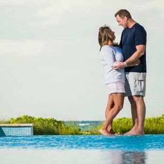 Couple posing by the pool at The Somerset on Grace Bay