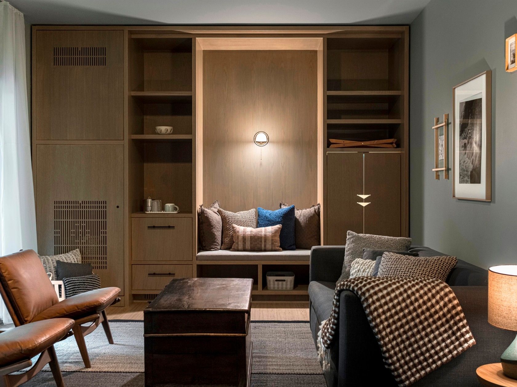 Living room with couch, coffee table, chairs, built-in shelving, and recessed lighting in the built-in.