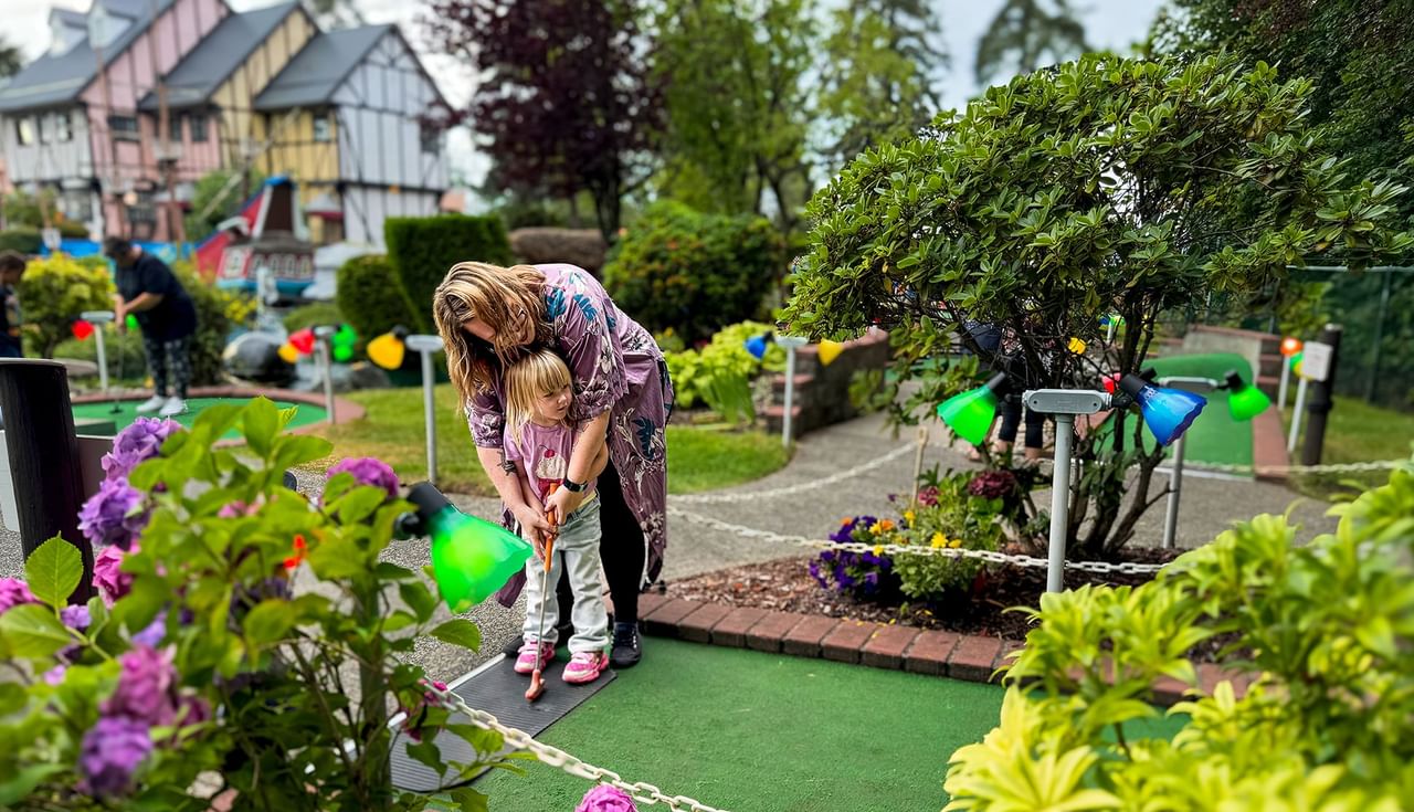 Mother and child playing mini golf